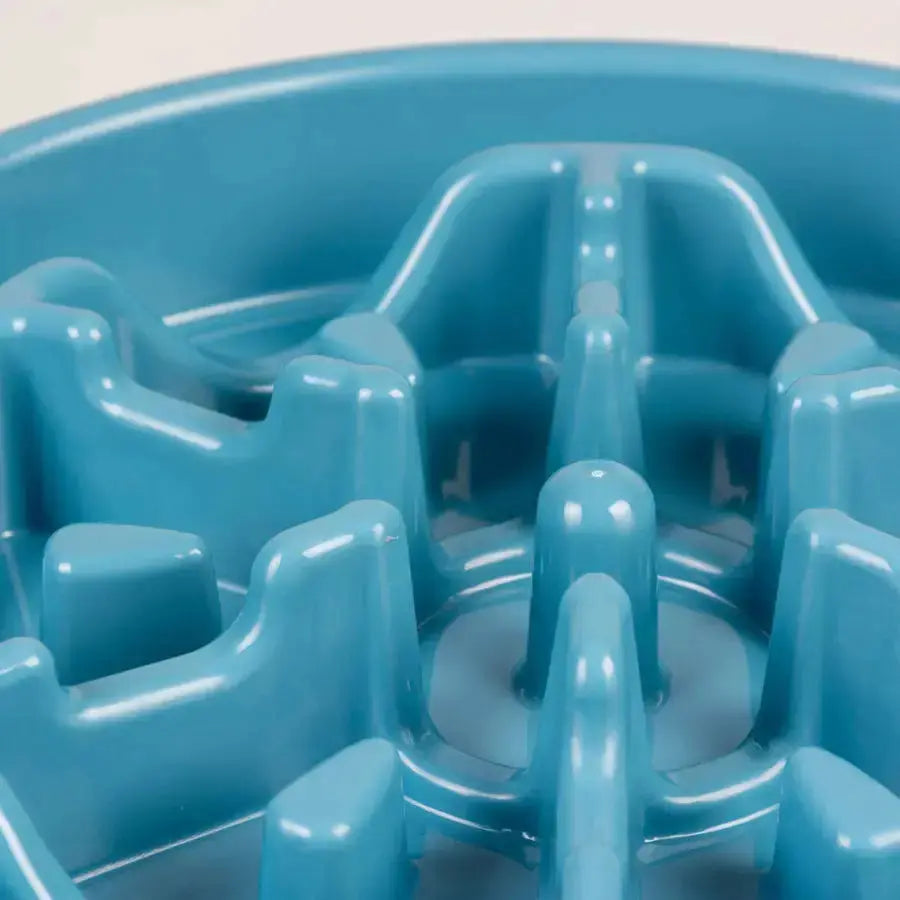 Découvrez le gros plan de la gamelle anti-glouton pétrole Duvoplus Gamelle, 700 ml, taille M (25,5 x 25,5 x 5 cm). Cette gamelle bleue texturée pour animaux de compagnie est dotée de crêtes surélevées en forme de labyrinthe pour ralentir l'alimentation et favoriser la santé animale, avec des surfaces lisses et brillantes.