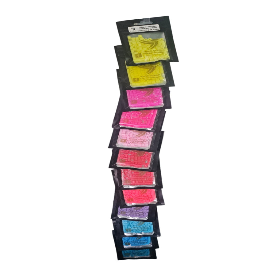 Présentation verticale de sachets Bague de marquage ouverte aux couleurs vives de BIRD SHOP ORNITHOLOGIE LUXEMBOURG, chacun d'une teinte différente dans un motif en zigzag comme une bague exotique. Couleurs disponibles : jaune, rose, rouge, violet, bleu ; détails du sachet partiellement visibles.