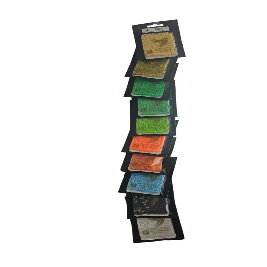Un présentoir vertical de neuf paquets de cartes de jeu exotiques, chacun dans une teinte différente comme l'or, le vert, le rouge, le bleu et le blanc, disposés sur un fond blanc immaculé. Produit : Bague de marquage ouverte pour exotique 2,4 mm-3,00 mm / 100 pièces par BIRD SHOP ORNITHOLOGIE LUXEMBOURG.