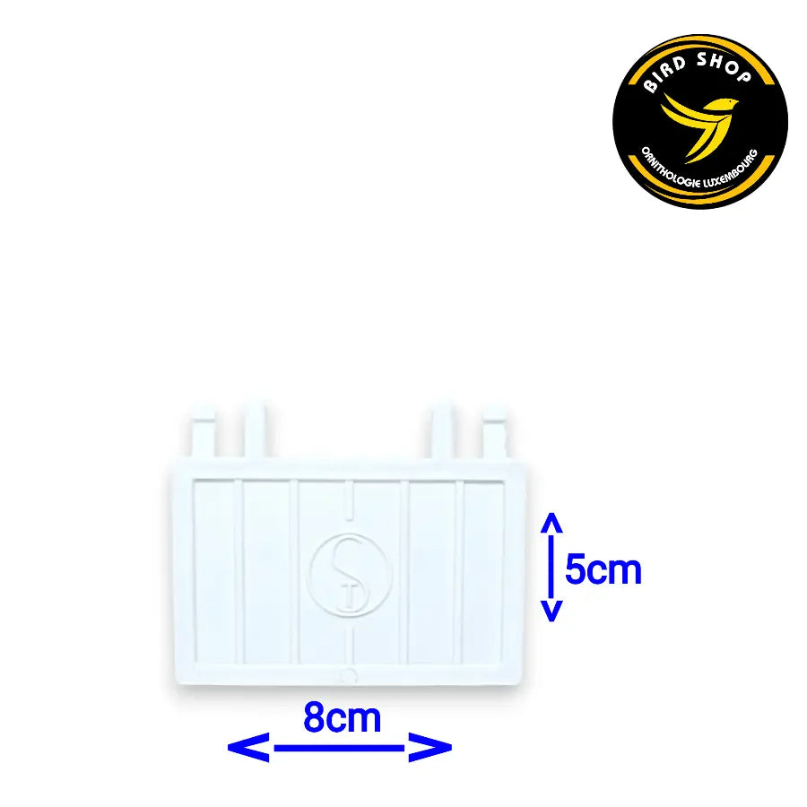 Le Clapet pour devanture OST est un rectangle en plastique blanc de 8 cm de large et 5 cm de haut, avec deux petites protubérances supérieures. Il est indispensable pour les éleveurs d'oiseaux, avec un logo en forme de silhouette d'oiseau et le texte "BIRD SHOP" dans le coin supérieur droit.